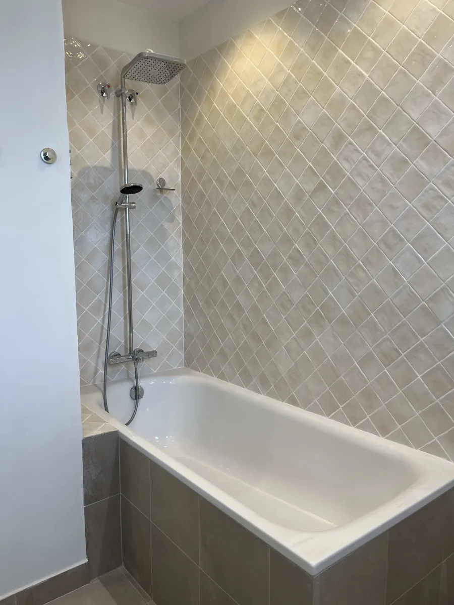 Detalle de grifería termostático grohe en bañera y alicatado en reforma integral via laietana barcelona