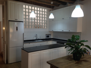 Cocina lacado blanco con pabes y vigas de madera. Sant Andreu. Barcelona