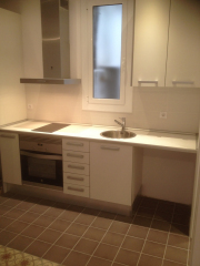 Cocina abiertacon mobiliario económico de melamina en reforma pequeño piso El Raval. Barcelona