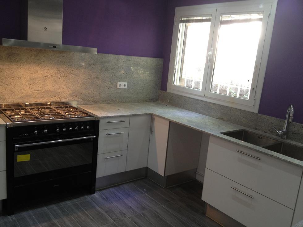 Cocina de alta gama en una casa de Sant Cugat con encimera y frontal de pared realizados en granito natural, mobiliario moderno y diseño elegante en Barcelona.