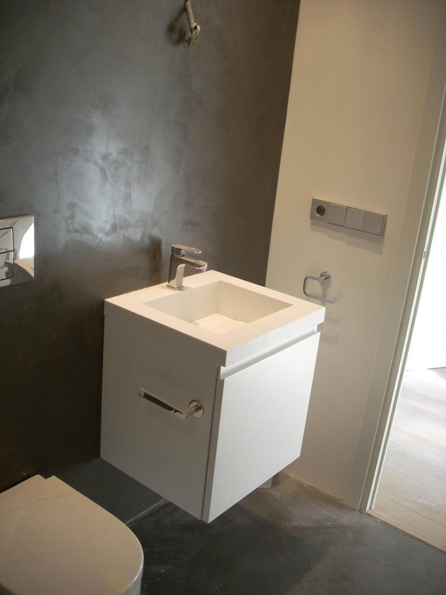 Baño de cortesia con microcemento y pequeño mueble de baño blanco. Reforma Ganduxer. Sarria. Barcelona
