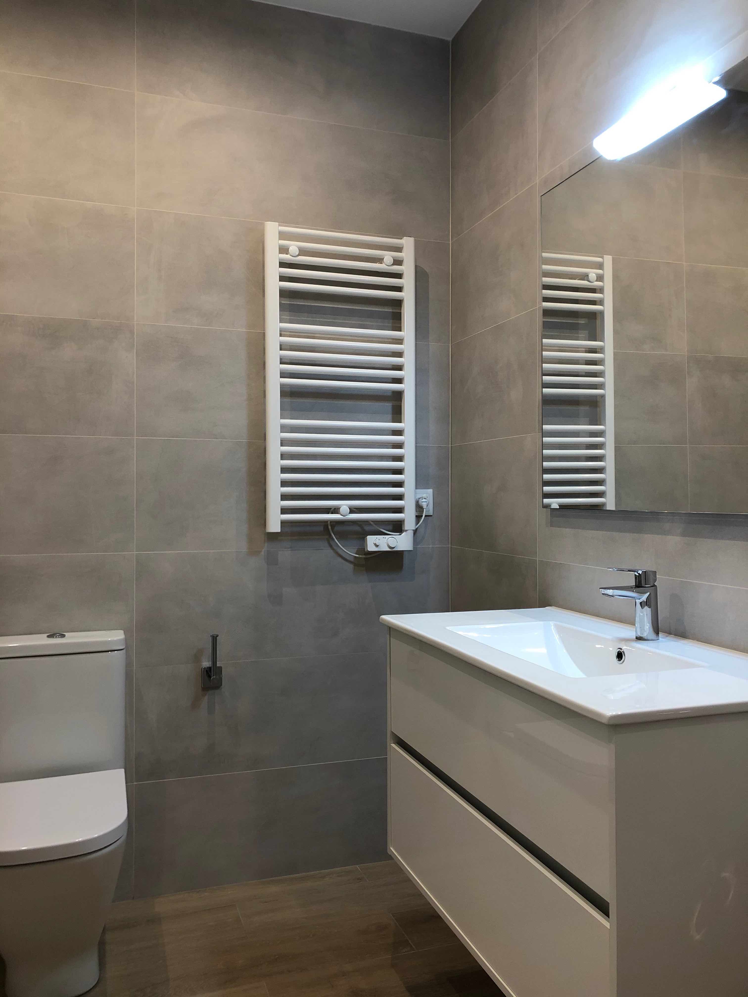 Mueble baño con baldosa de gran formato tonos grises en reforma integral de vivienda en Carrer Sicilia. Eixample, Barcelona.