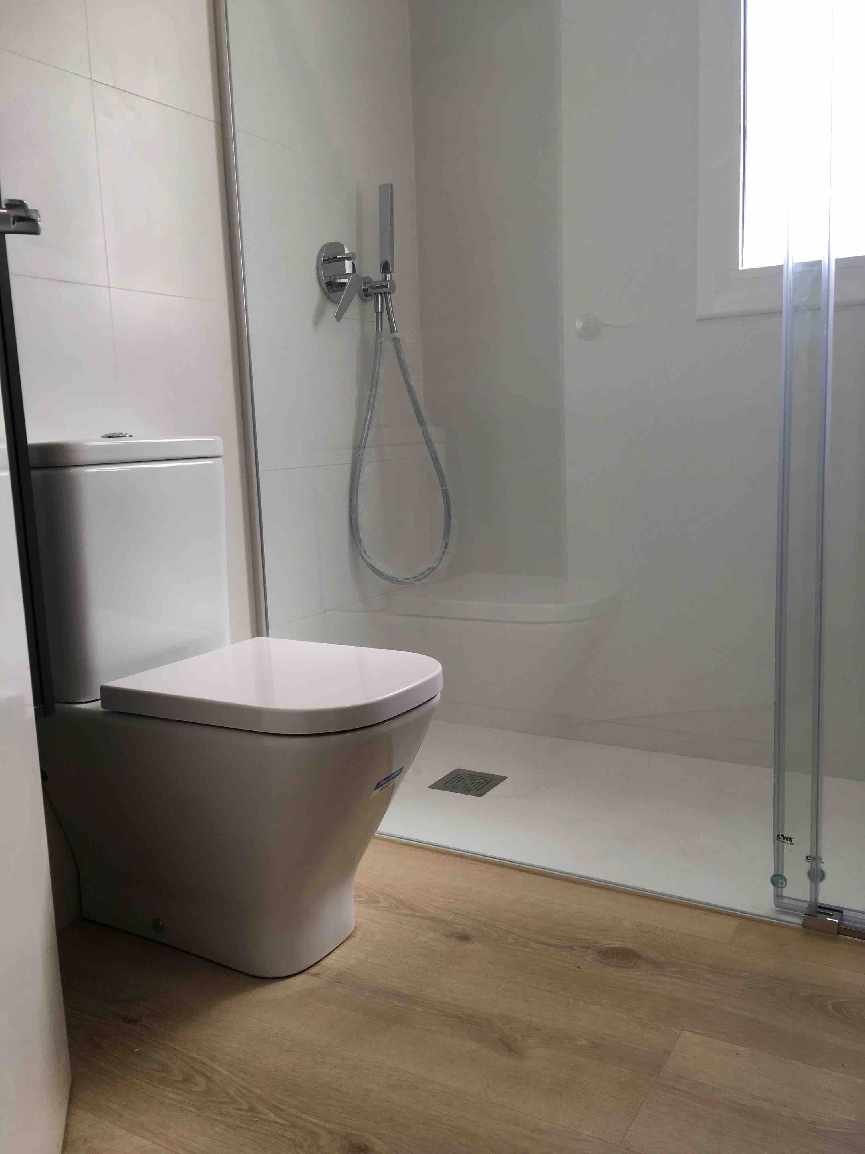 Plato de ducha de resinas con suelo laminado Quick Step. Reforma integral Cornella. Barcelona