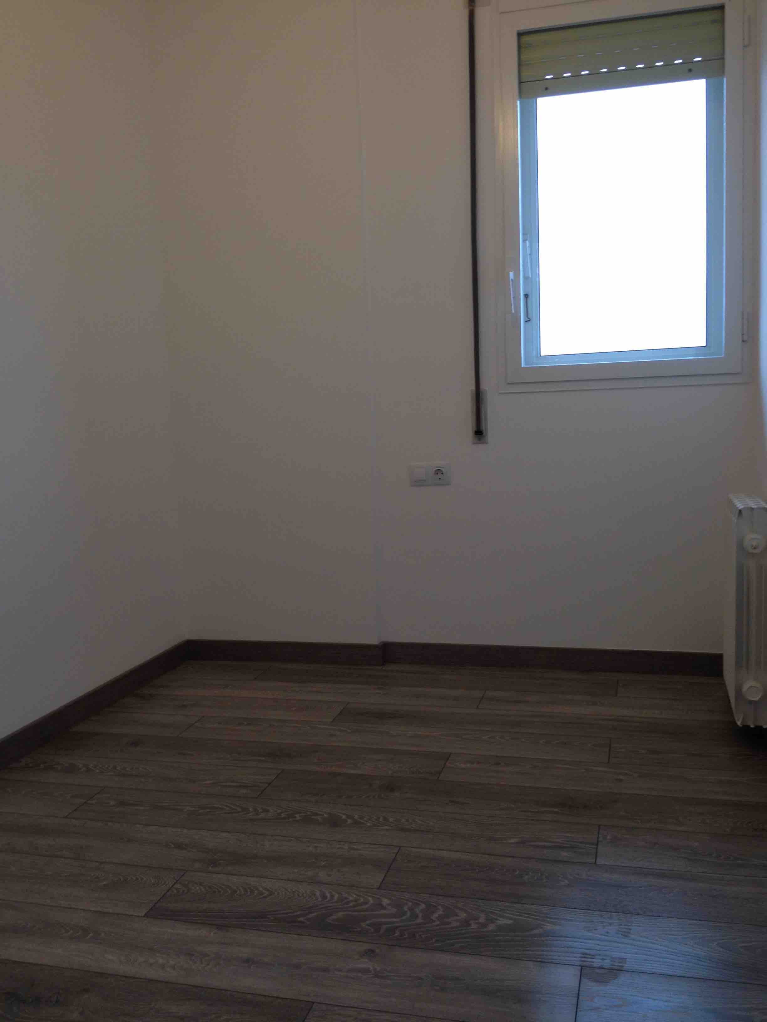 Reforma Integral de piso de 80m2 en Carrer Josep Pla de Barcelona. Vista de suelo Quick Step y carpintería de aluminio con RPT. Barrio de Sant Martí. Barcelona