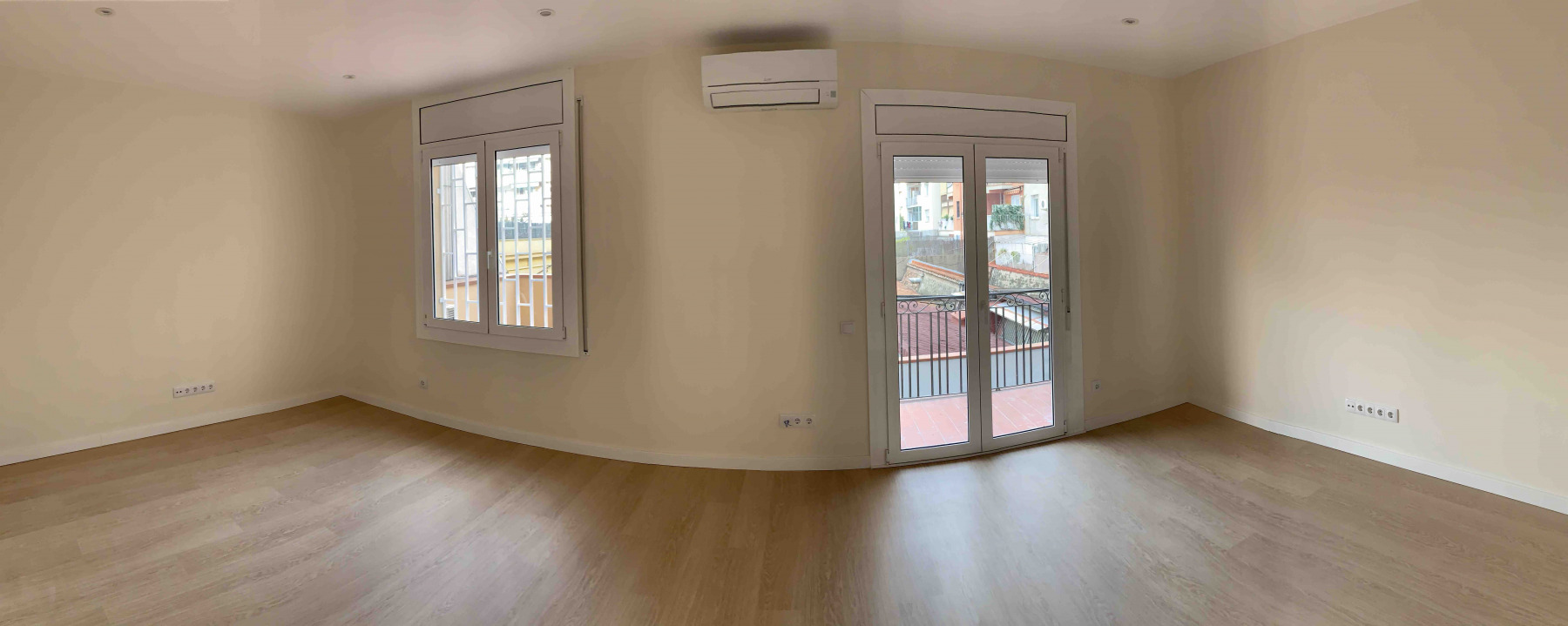 Perspectiva más amplia del salón con aire acondicionado y carpintería exterior de alta eficacia. Reforma integral piso en Carrer Padilla. reforma Eixample. Barcelona