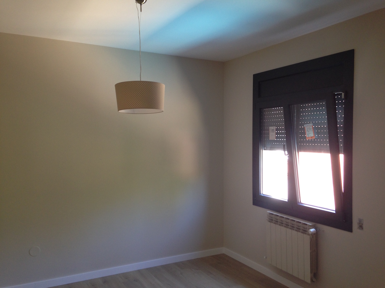 Habitación principal en Sant Just Desvern con paredes pintadas en tono café con leche, suelo de madera y ventanas de aluminio con rotura de puente térmico (RPT) en Barcelona.