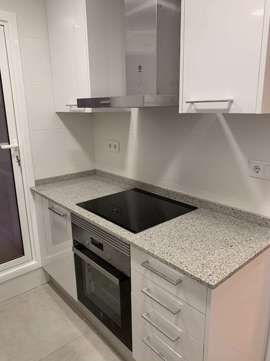 Encimera de granito con placa de inducción. reforma integral de piso en Carrer Padilla. Sagrada Familia. Barcelona