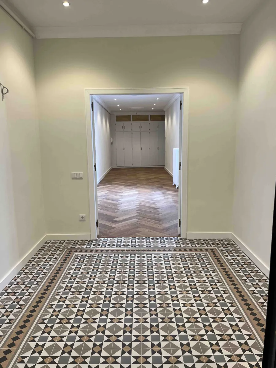 Detalle del suelo de mosaico hidráulico en zona recibidor conbinado con suelo de roble natural en zona biblioteca. Reforma integral de piso en Via Laietana. Gòtic. Barcelona