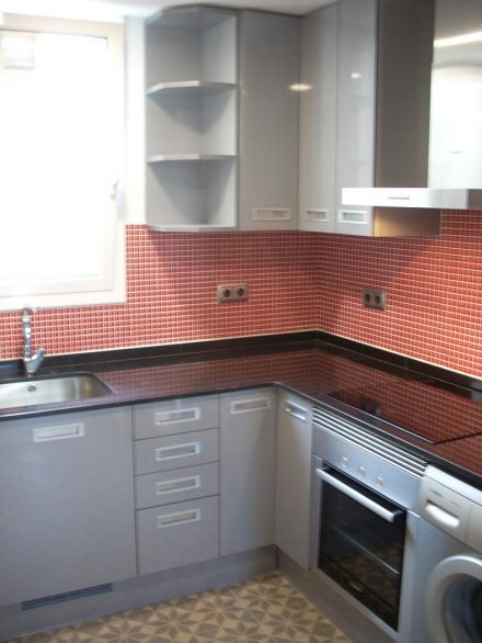 Cocina moderna en l'Eixample con mobiliario en gris grafito, encimera de piedra negra y diseño minimalista en la calle Aribau, Barcelona.